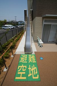施設の外構・駐車場エリア。避難空地と表示された敷地の上空を示す
