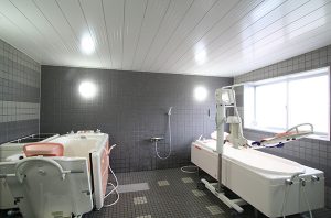 大型浴槽が2つ並ぶ介護浴室。手すりや洗い場などが完備